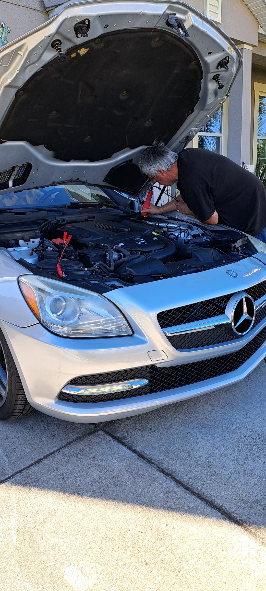 A man working on the hood of a car