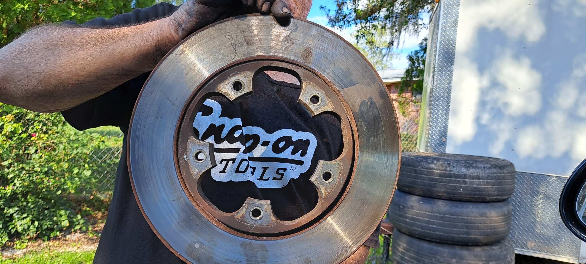 A man holding a large metal disc in his hands