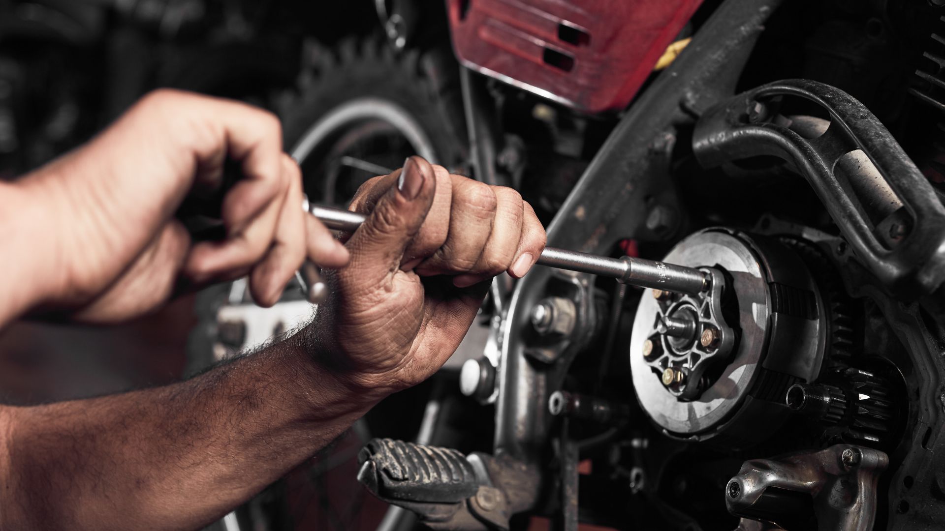 A man working on a motorcycle with a wrench