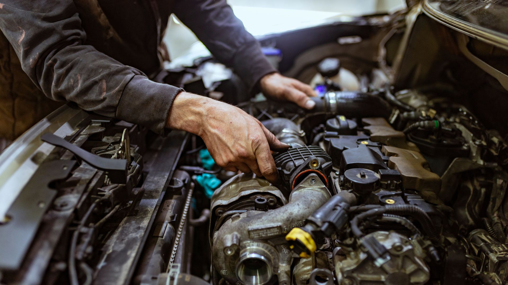 A man working on a car engine in a garage